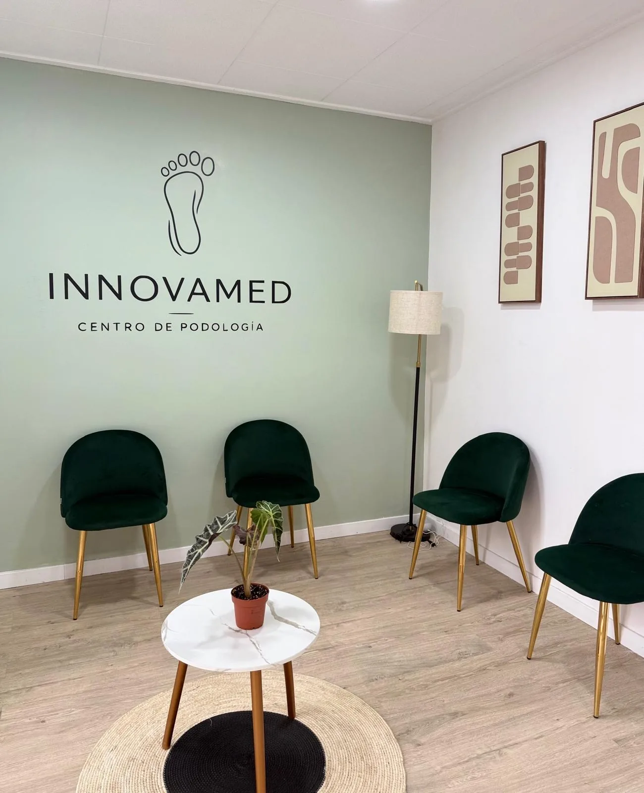Sala de espera de la Clínica Podológica Innovamed, con el nombre de la clínica en la pared